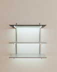 Modular shelving unit with satin shelves, satin vertical posts, and one bay, shown with three open shelf levels.