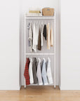 Closet storage system with white shelves and white vertical posts, plus hanger bars, shown with open shelving and one open shelf level.