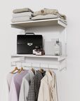 Closet storage system with white shelves and white vertical posts, plus hanger bars, shown with open shelving.