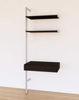 Desk shelving unit with black shelves and satin vertical posts, shown with desk surface and open shelf levels.