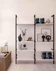 Modular shelving unit with satin shelves and satin vertical posts, one bay, styled in a modern room.