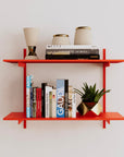 Modular shelving unit with orange shelves, orange vertical posts, and one bay, shown with two open shelf levels.