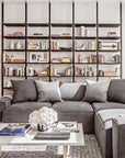 Floor-to-ceiling room divider shelving unit with lower storage cabinets with Tea for Two shelves and satin vertical posts, one bay, 24-inch bay width, six open shelf levels, floor-to-ceiling supports, styled in a room setting with books and decor.