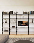 Modular media shelving unit with black shelves and black vertical posts, one bay, styled as an entertainment storage unit.