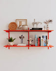 Modular shelving unit with orange shelves, orange vertical posts, and one bay, shown with two open shelf levels.