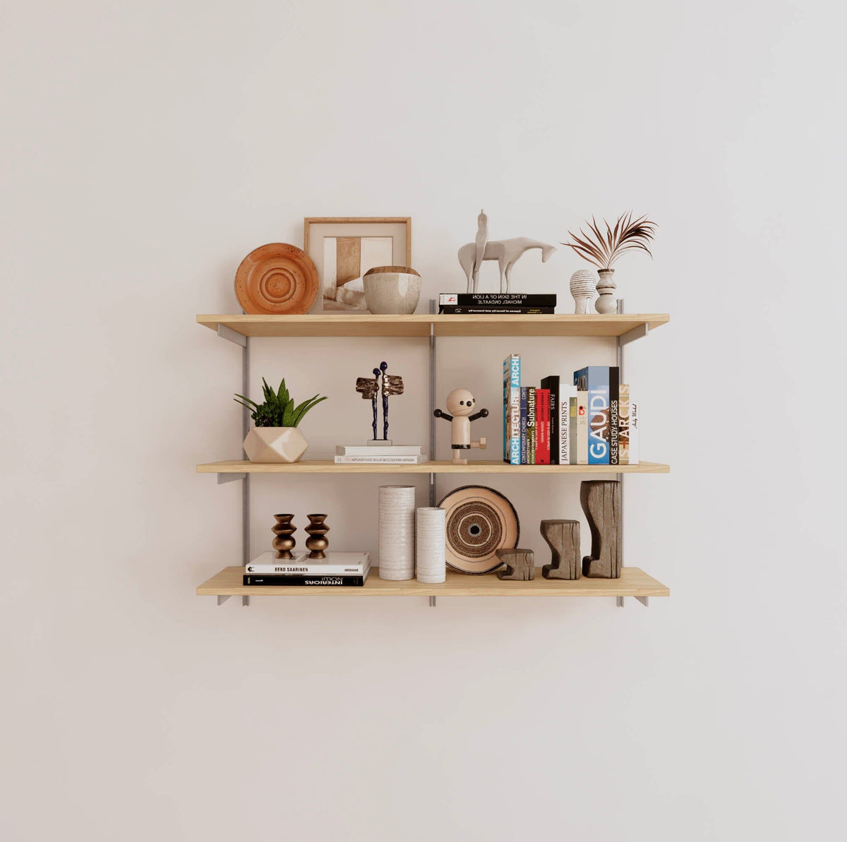 Modular shelving unit with Casting Light shelves, satin vertical posts, and one bay, shown with three open shelf levels.