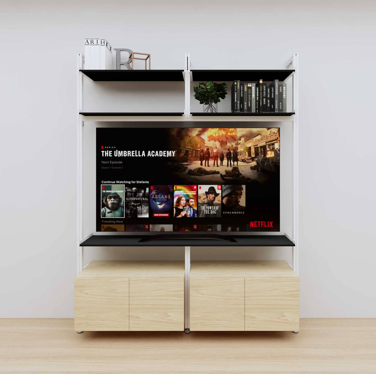 Modular media shelving unit with black shelves and white vertical posts, with Casting Light wood cabinet storage, two bays, shown with open shelf levels.