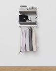 Closet storage system with white shelves and white vertical posts, plus hanger bars, shown with open shelving.