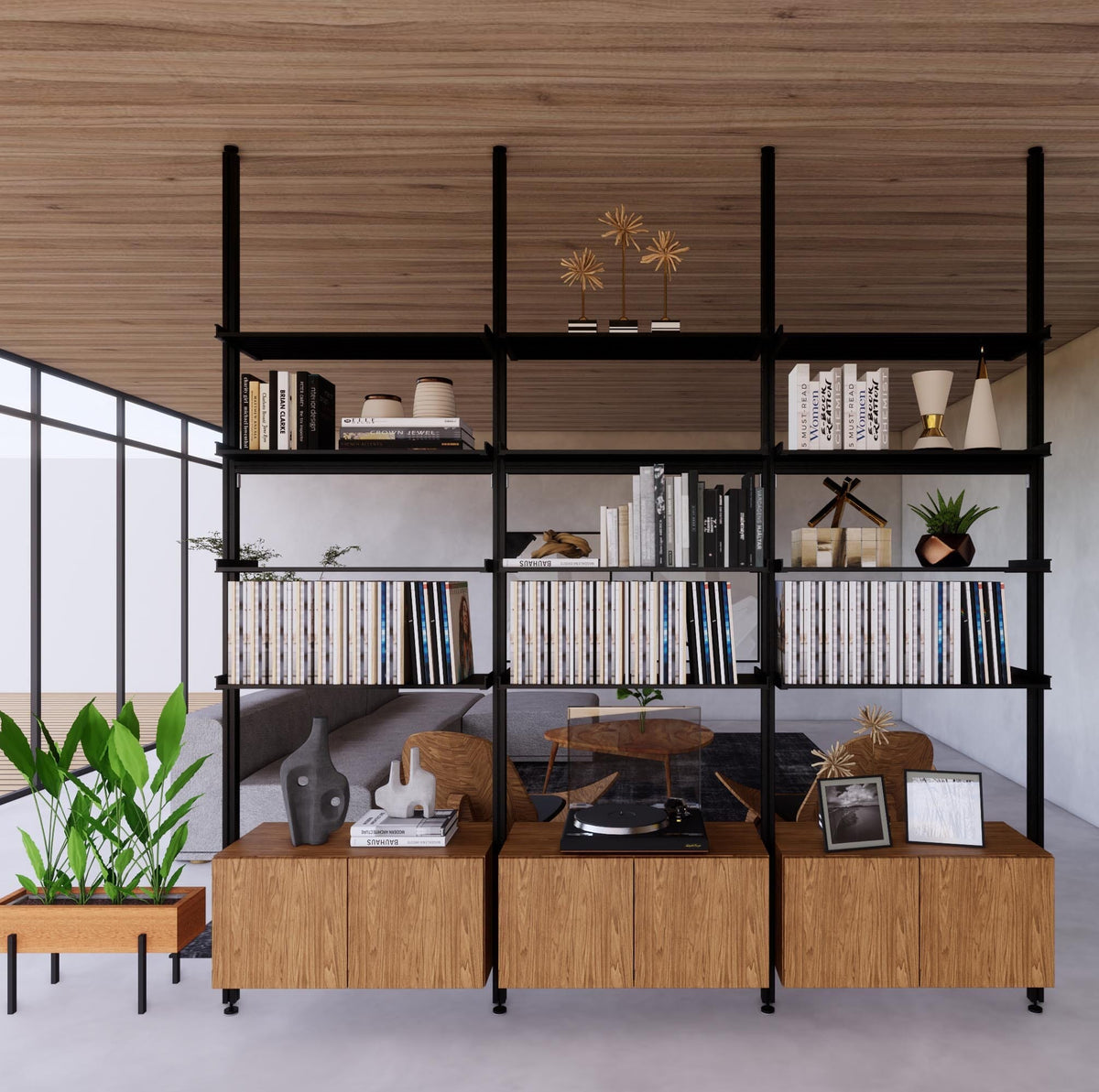 Floor-to-ceiling room divider shelving unit with lower storage cabinets with black shelves and black vertical posts, 3 bays, 31-inch bay width, six open shelf levels, floor-to-ceiling supports, styled in a room setting with books and decor.