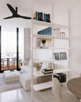 Floor-to-ceiling room divider shelving unit with satin shelves and satin vertical posts, one bay, 24-inch bay width, six open shelf levels, floor-to-ceiling supports, styled in a room setting with books and decor.
