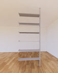 Floor-to-ceiling room divider shelving extension with lower storage cabinet with satin shelves and satin vertical post, one bay, 31-inch bay width, six open shelf levels, floor-to-ceiling supports.