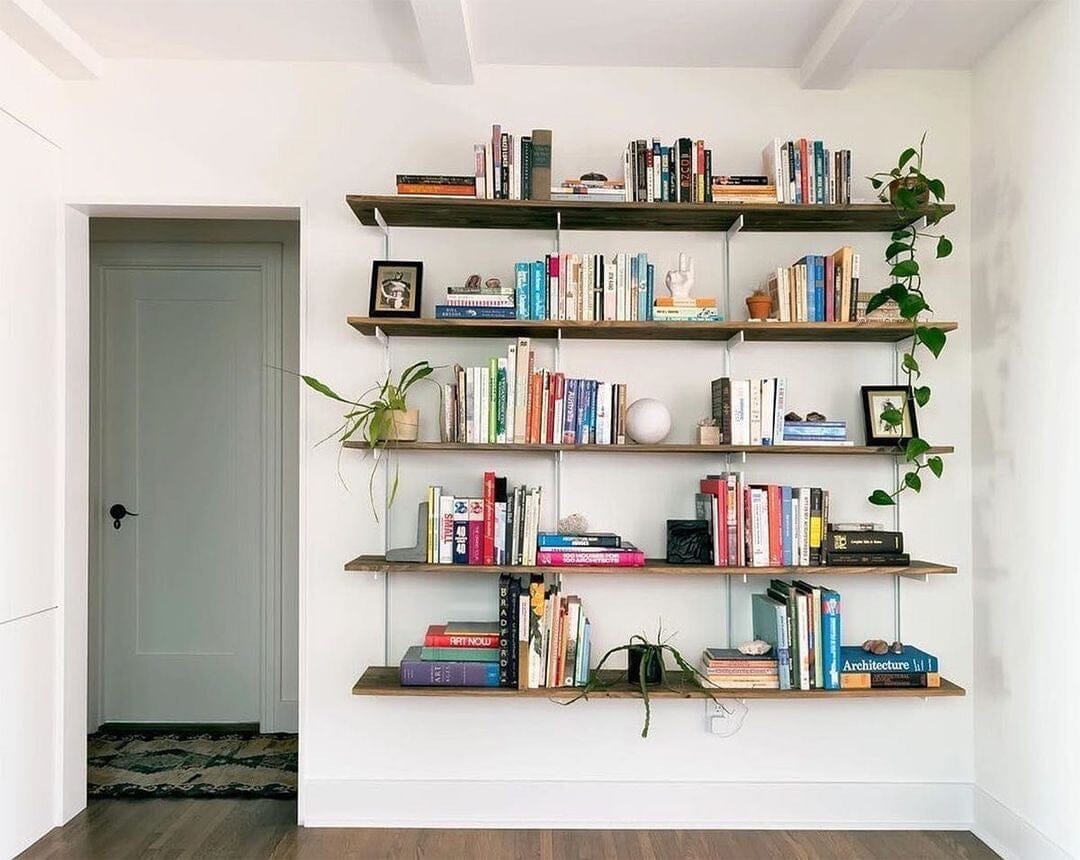 Modular shelving unit with Casting Light shelves, satin vertical posts, and one bay, shown with two open shelf levels styled in a room setting.