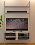 Modular media shelving unit with satin shelves and satin vertical posts, shown with eight open shelf levels.
