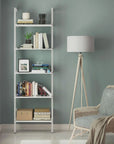 Modular shelving unit with black shelves and satin vertical posts, one bay, styled in a modern room.