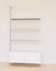 Retail display shelving unit with white shelves, satin vertical posts, and base cabinets in a 48-inch configuration, shown with open display shelving.