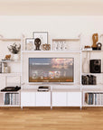Harmony four-bay media unit with white shelves and white vertical posts, four bays, shown with open shelf levels.